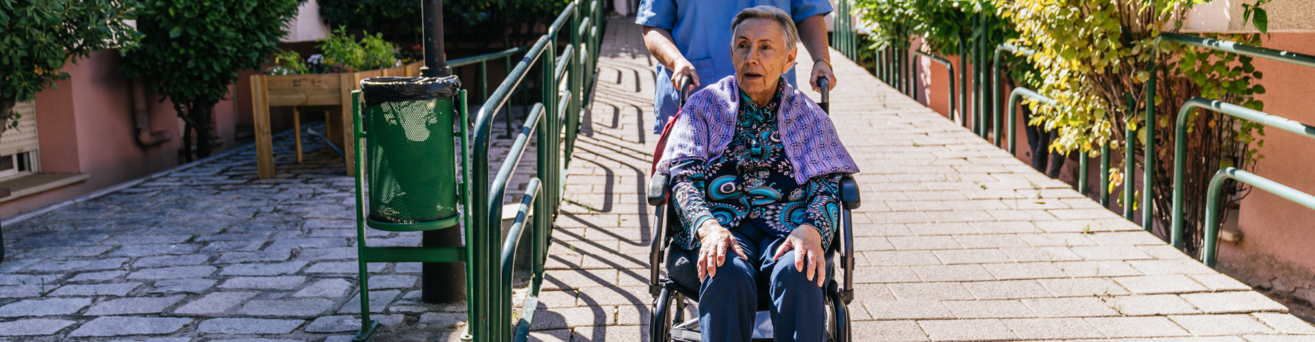 a woman pushing an elder on a wheelchair